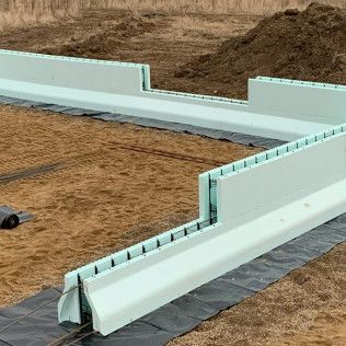 A foundation for a house is being built on a dirt field.