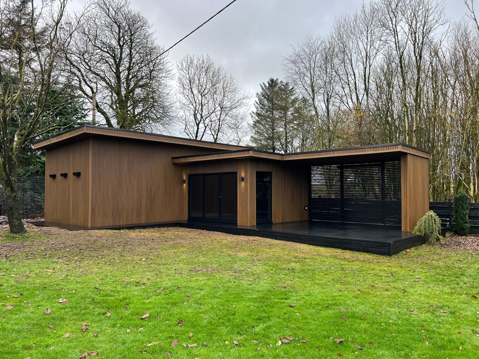 Large garden room in Newton Mearns with 10m x 5m covered entertainment space, featuring a stylish bar and private toilet, designed for outdoor living.