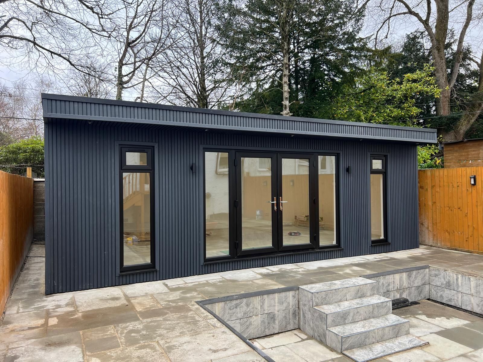 Large garden room in Newton Mearns with 10m x 5m covered entertainment space, featuring a stylish bar and private toilet, designed for outdoor living.