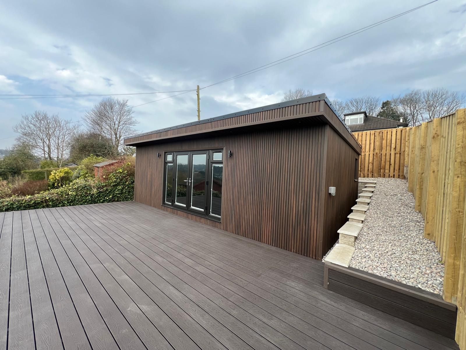 Modern 7.5m x 4m garden room in Glasgow with composite decking, built on a sloped garden site, designed as a stylish family retreat with outdoor appeal.