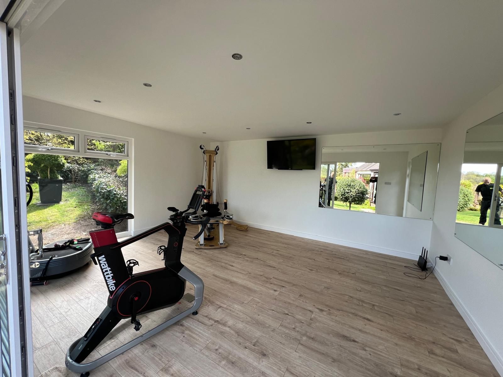 Home Gym Garden Room Equipment Layout Garden room gym with weights, treadmill, mirrors and training equipment showing a practical home gym layout