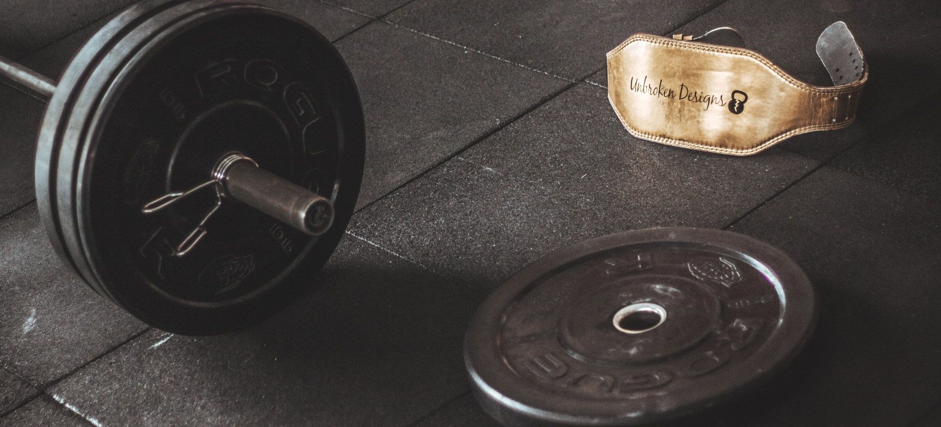 a barbell and weights are on the floor in a gym .