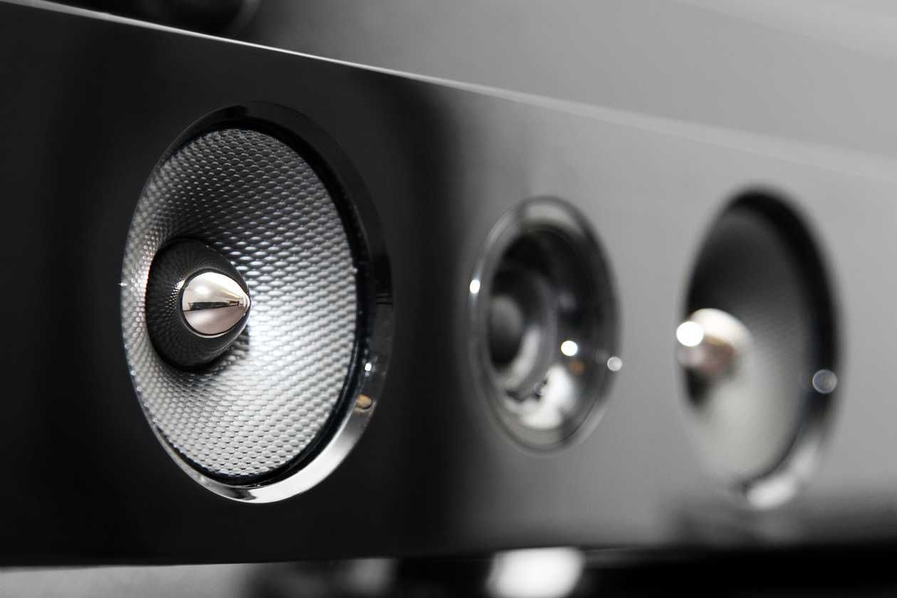 a close up of three audio speakers on a black surface