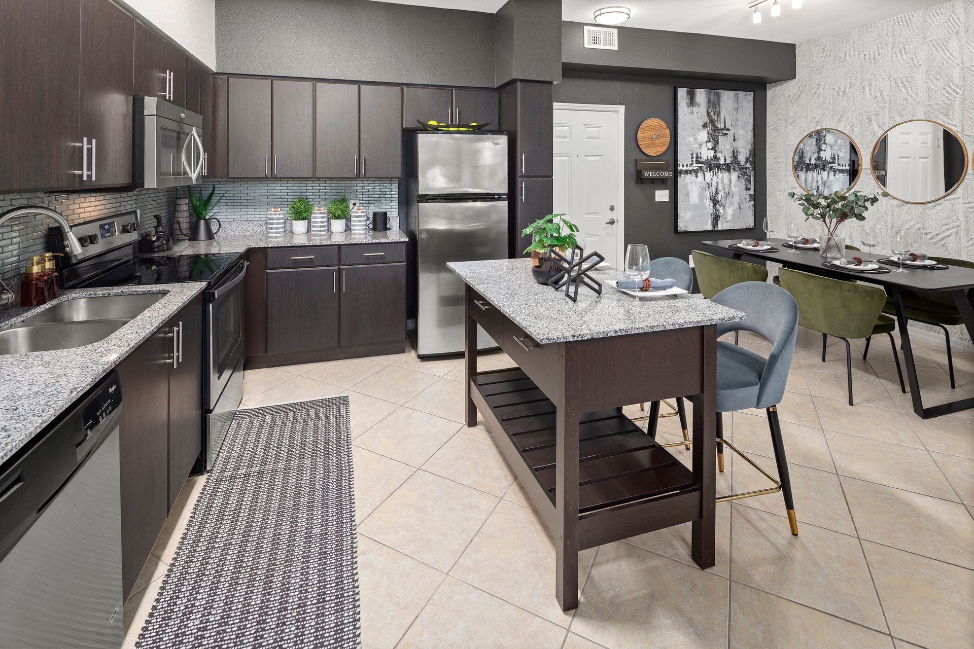Apartment kitchen with brown designer cabinet at Mosaic at Miramar Town Center.