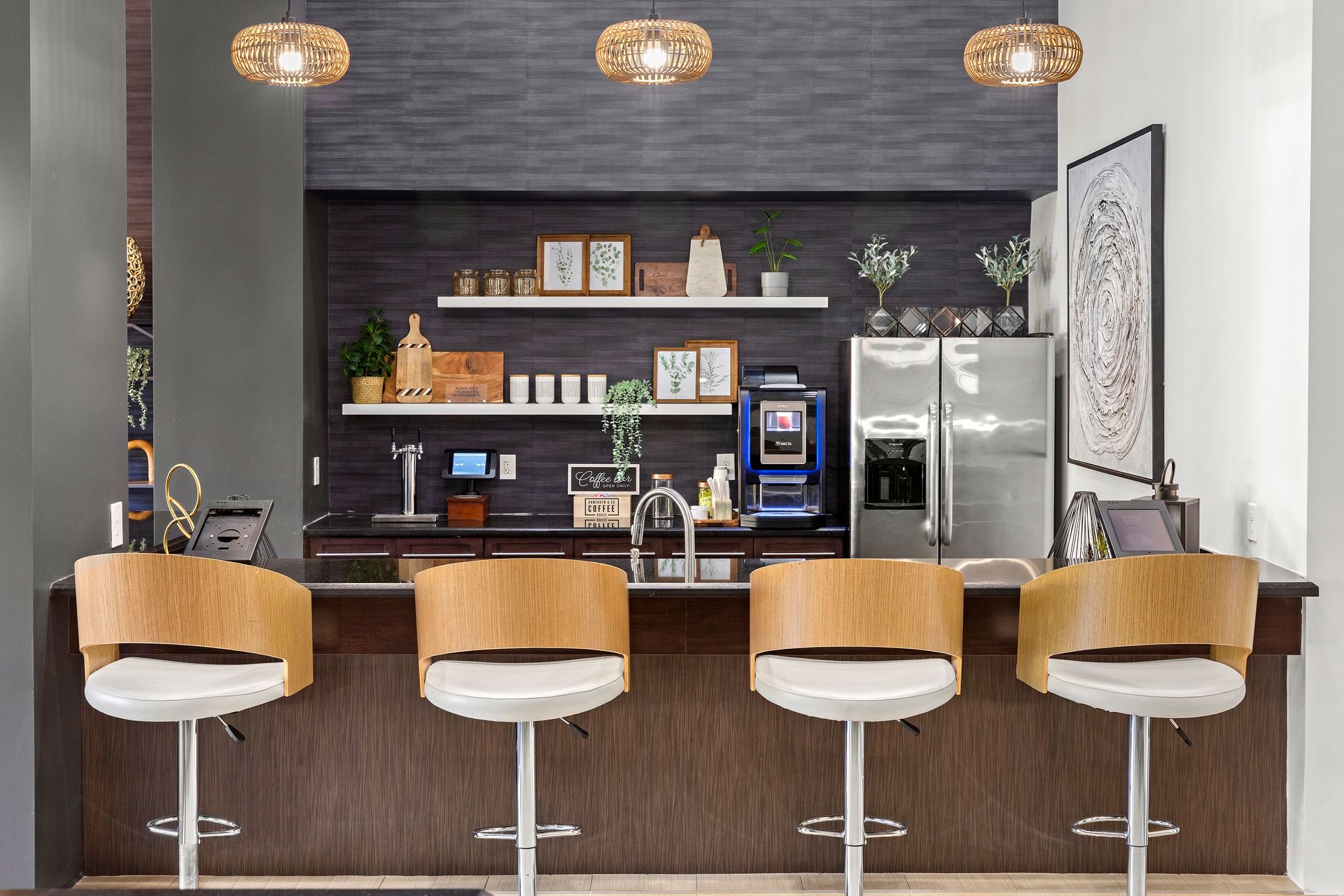 Community kitchen with bar seating and fridge at Mosaic at Miramar Town Center.