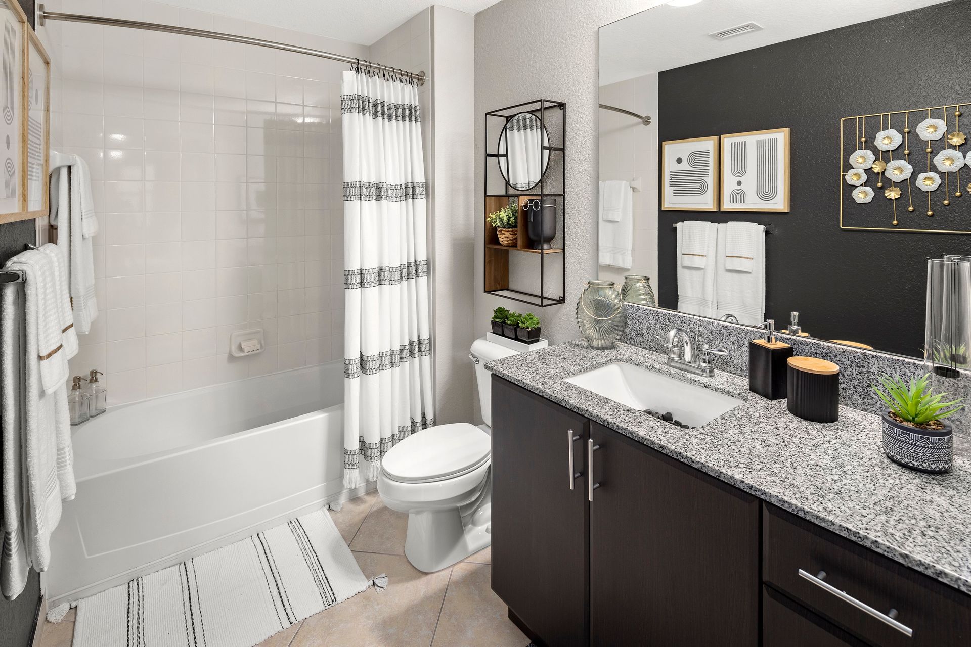Bathroom with shower, toilet, sink, and oversized mirror at Mosaic at Miramar Town Center.