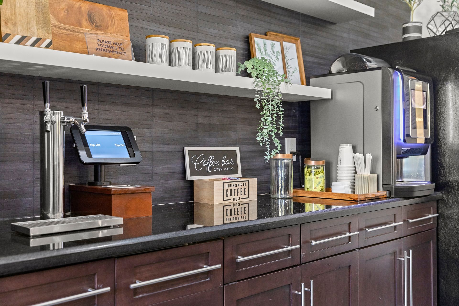 Apartment community kitchen at Mosaic at Miramar Town Center with coffee bar and fridge.