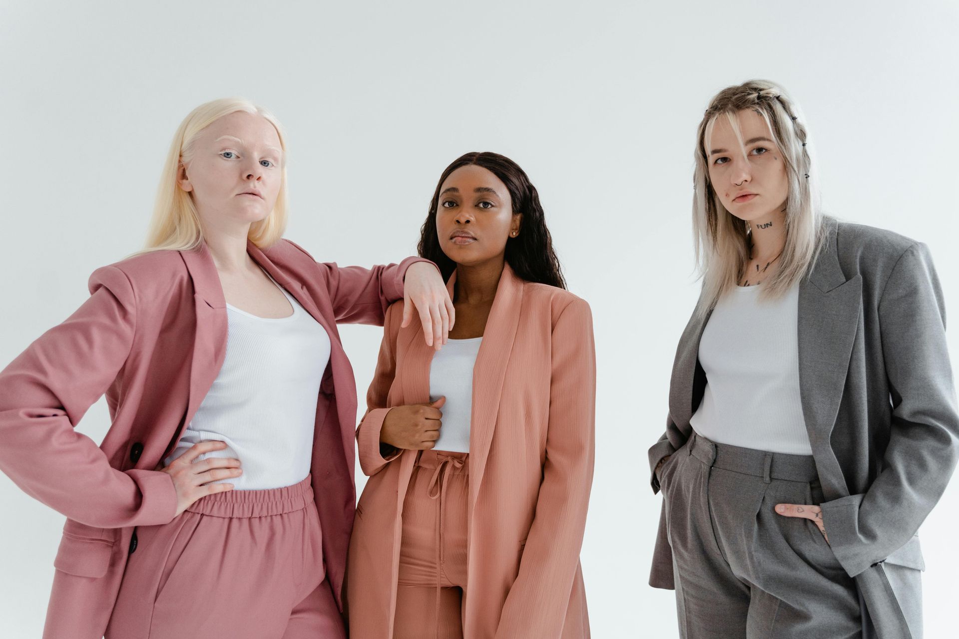 Three women are standing next to each other in suits.