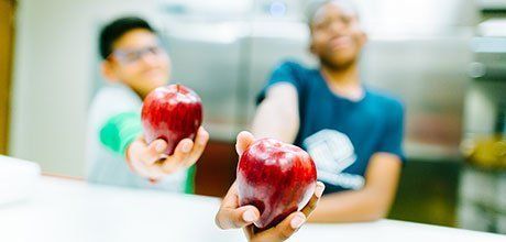 Two boys holding apples