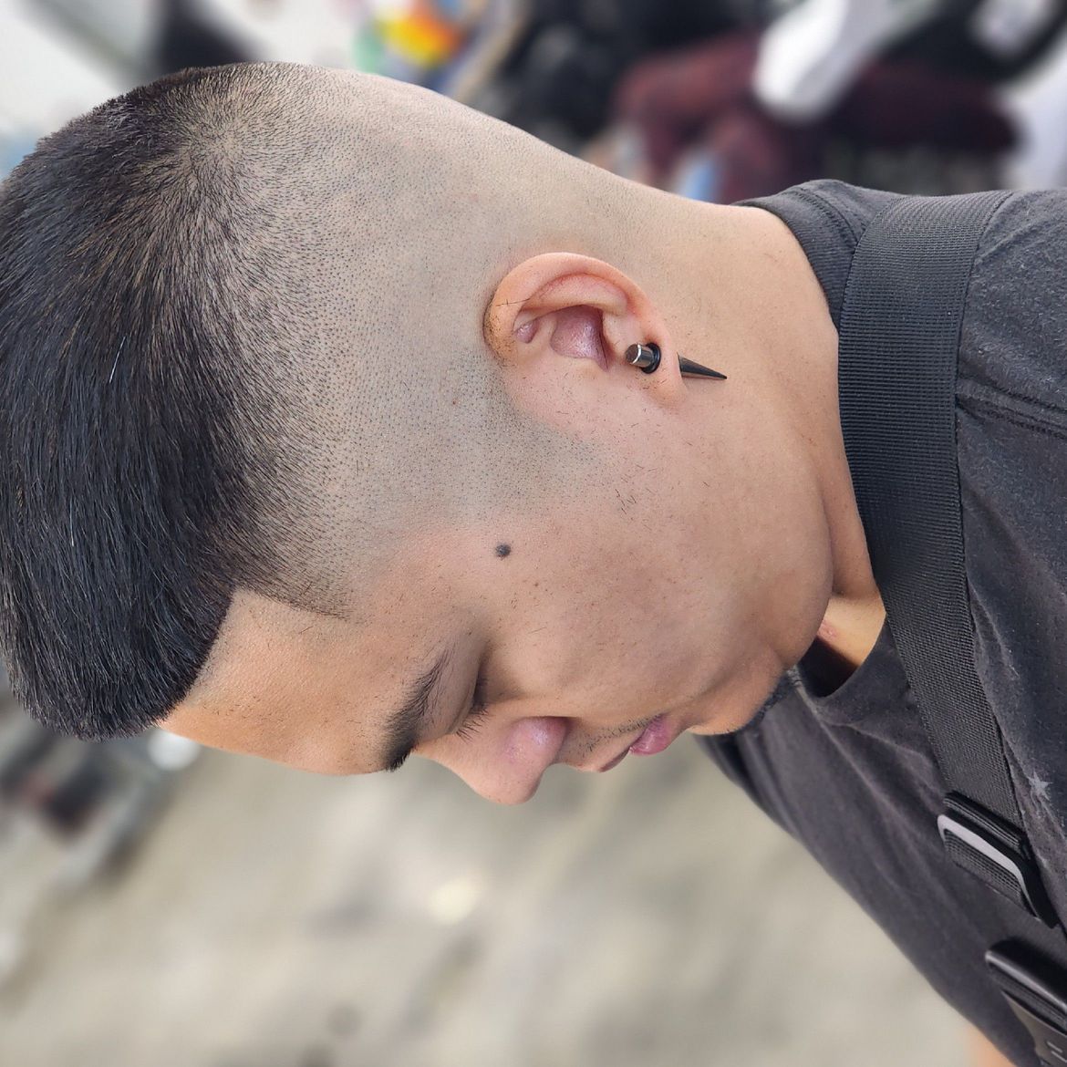 a close up of a man 's head with a black shirt on