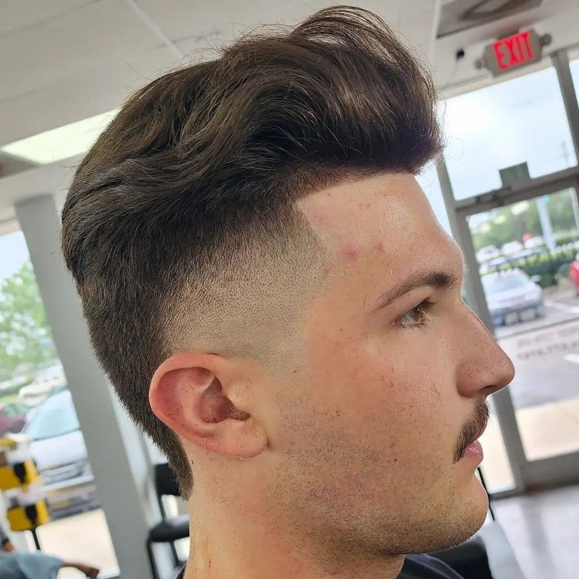 a man is getting his hair cut at a barber shop .