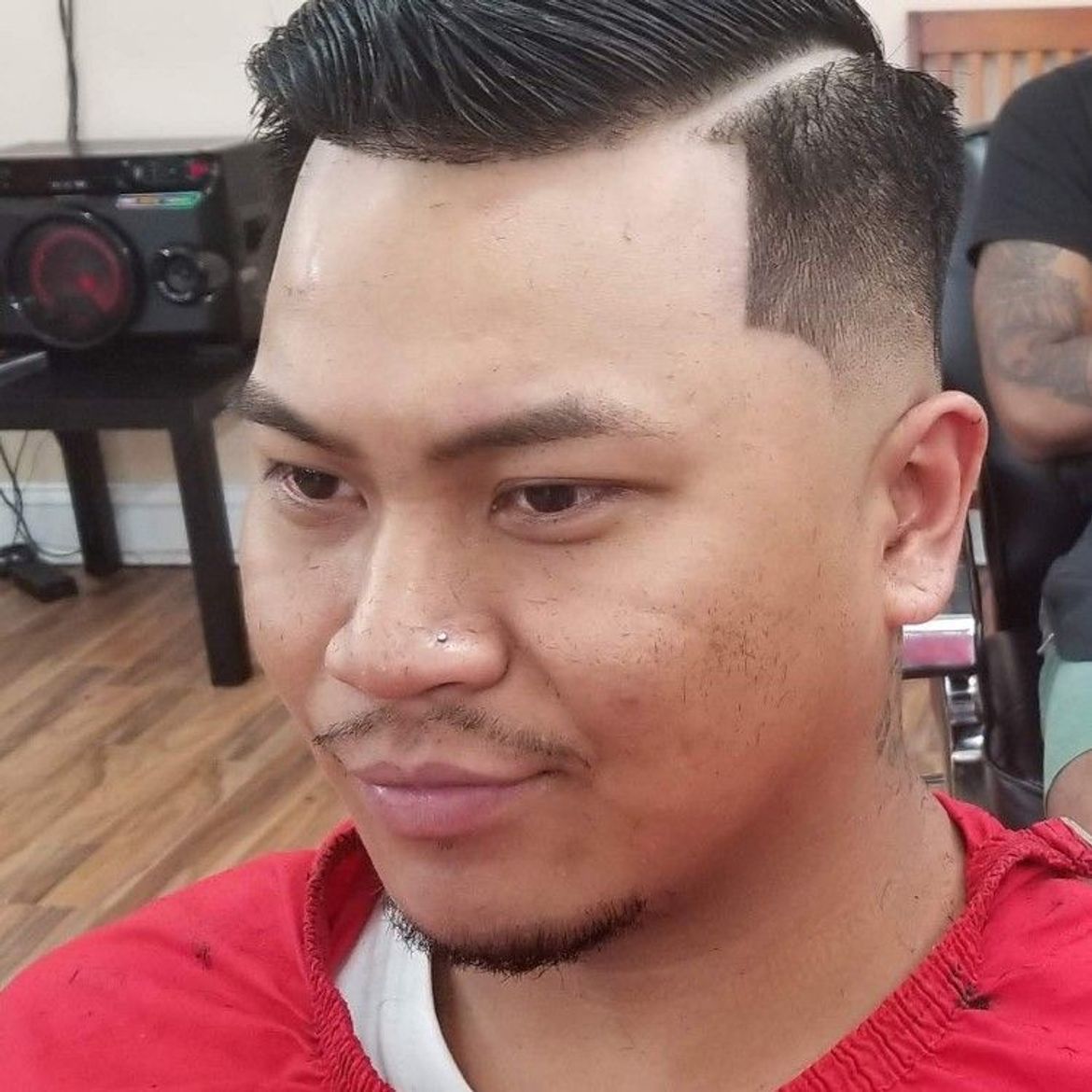 a man is getting his hair cut at a barber shop .