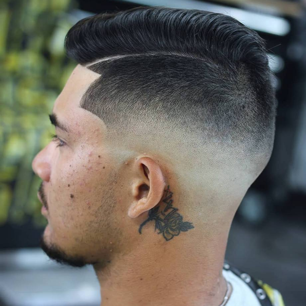 a man with a tattoo on his neck has a mohawk hairstyle .