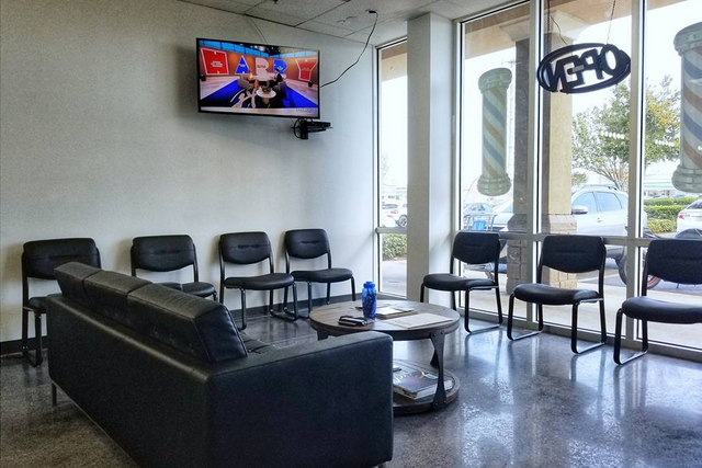 a waiting room with a couch and chairs and a television on the wall