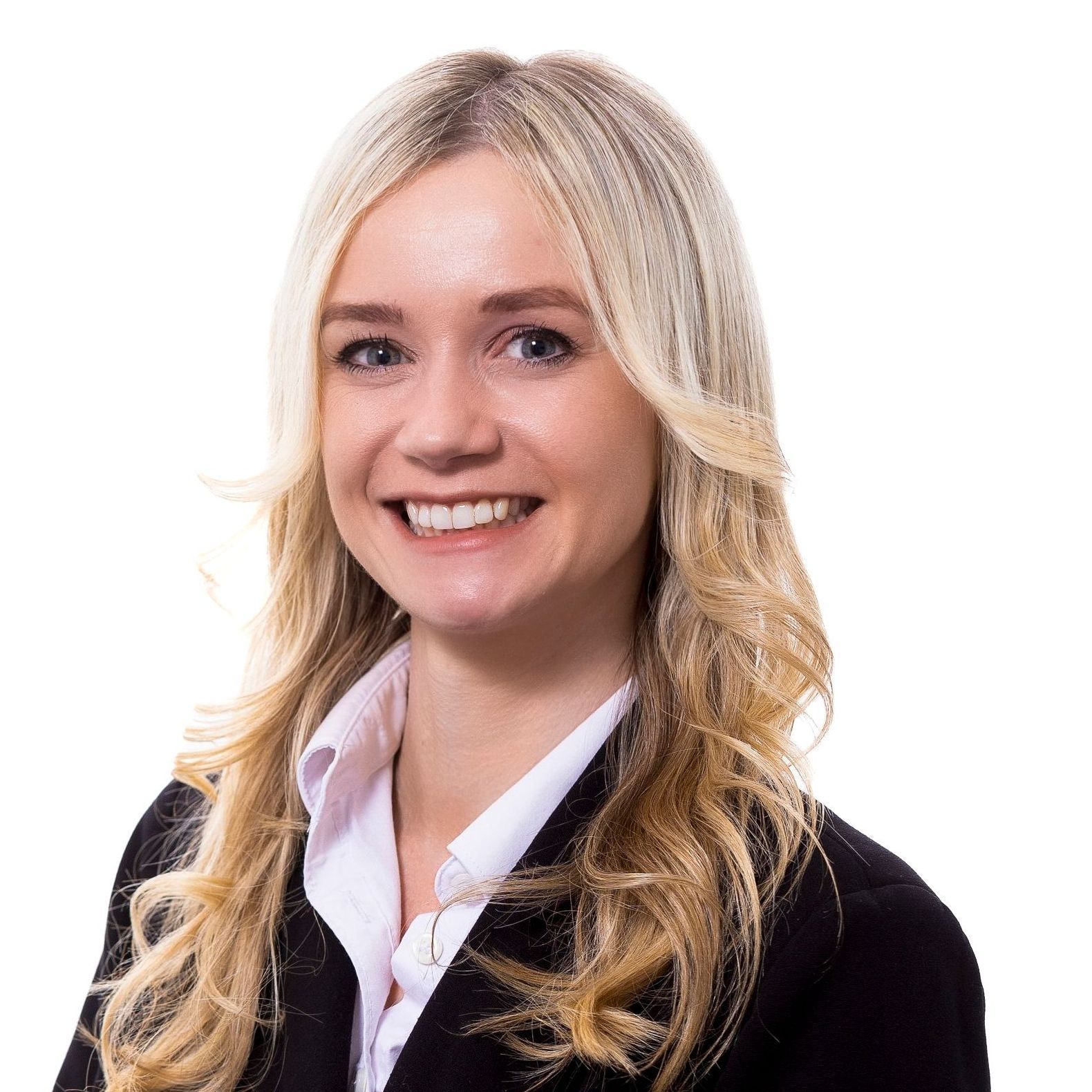 A woman with long blonde hair is smiling and wearing a black jacket and white shirt.