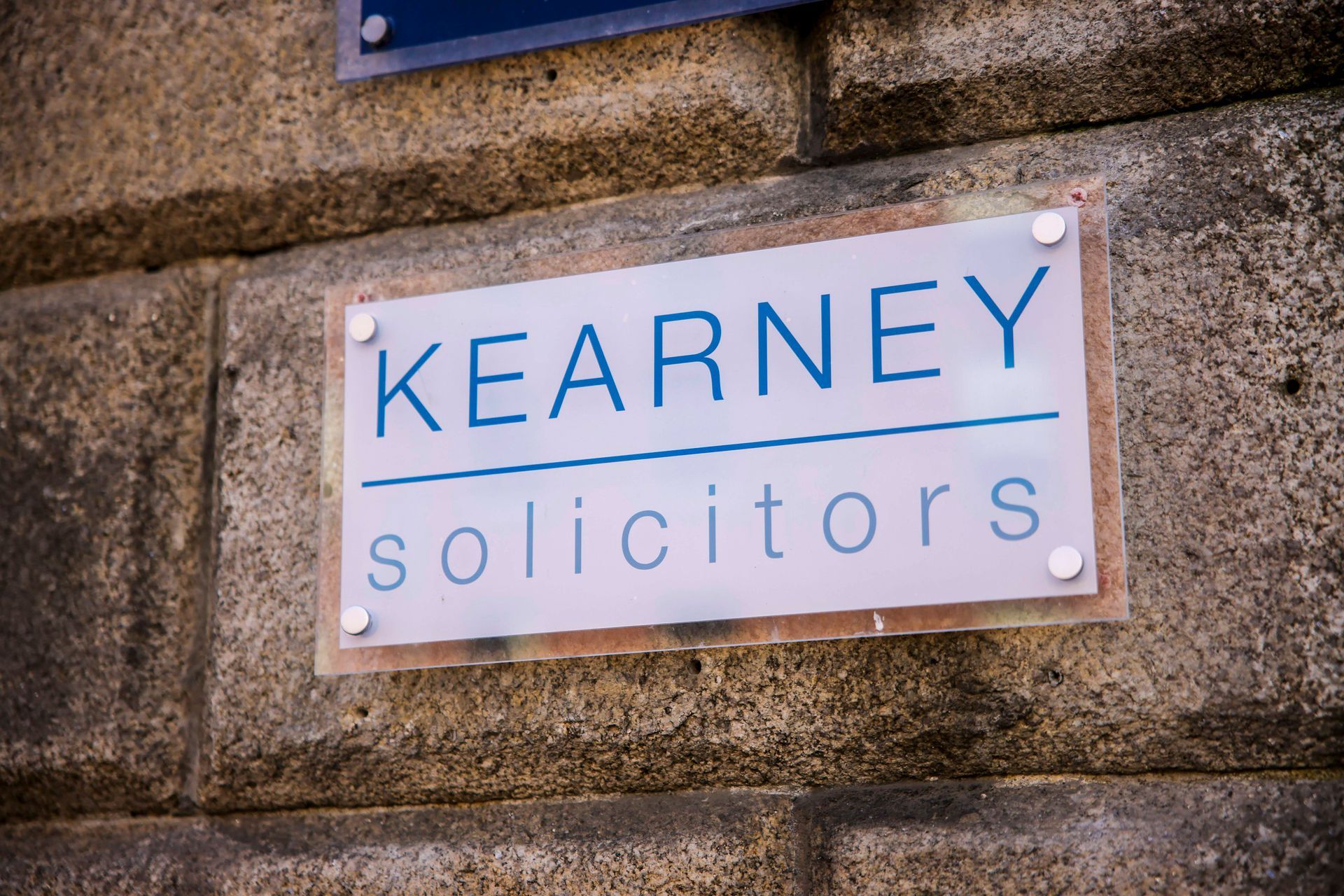 A sign on a brick wall says kearney solicitors