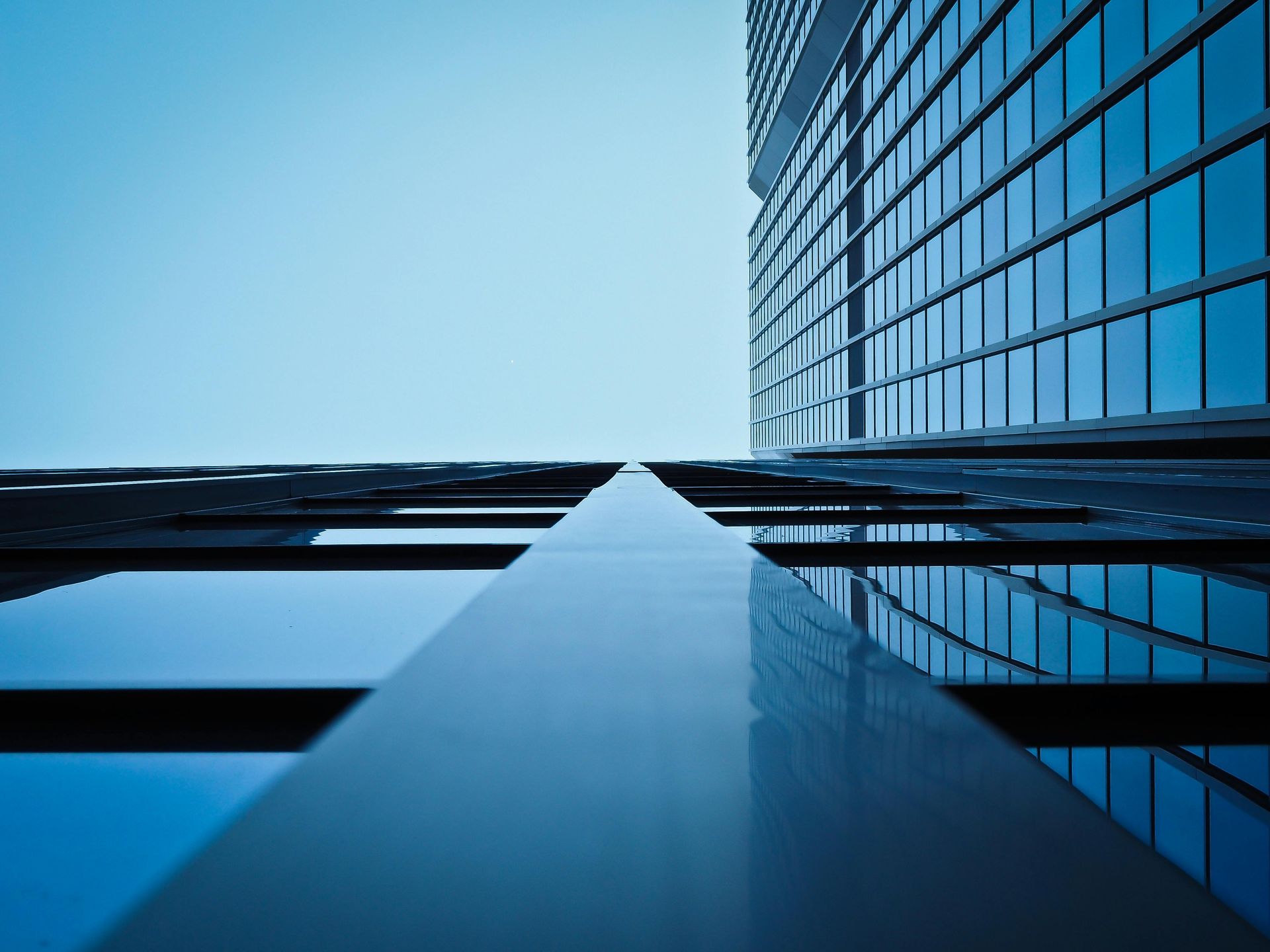 Looking up at a tall building with a blue sky in the background.