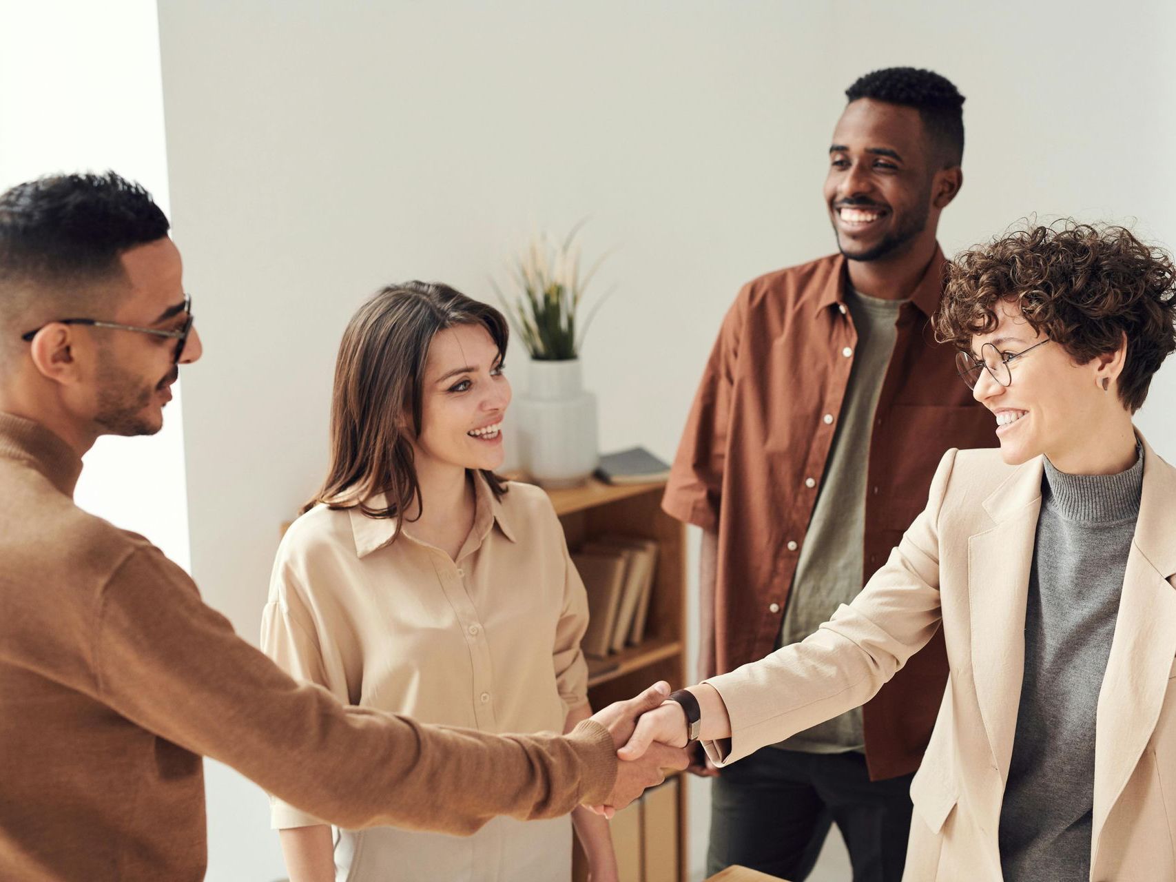 A group of people are shaking hands in a room.