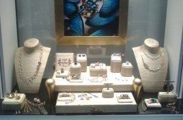 Una vetrina piena di gioielli e la foto di un uomo che tiene in mano un diamante.