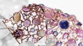 Primo piano di un braccialetto con pietre viola e blu su una superficie bianca.