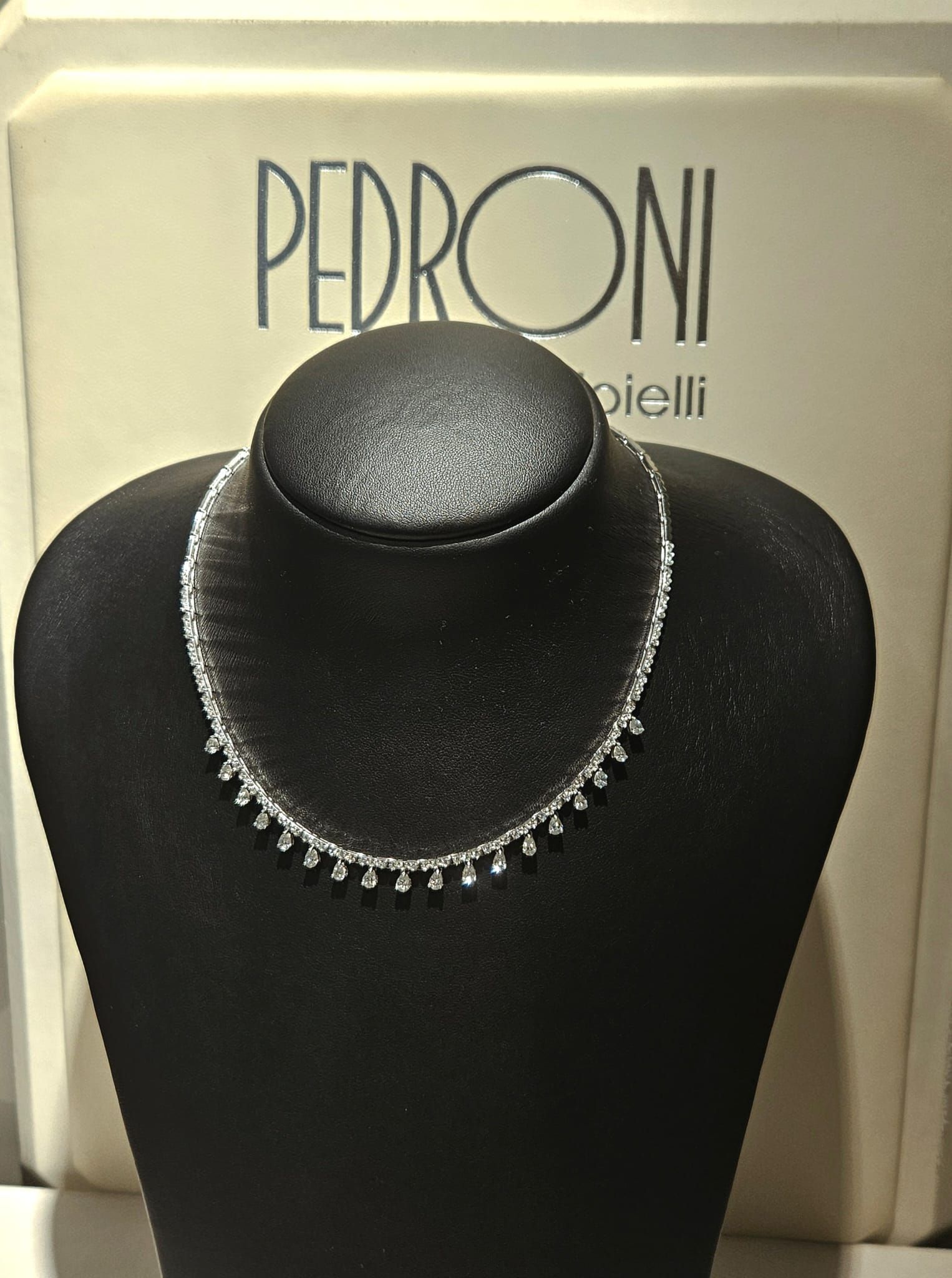 Una donna indossa una collana di perle e degli orecchini.