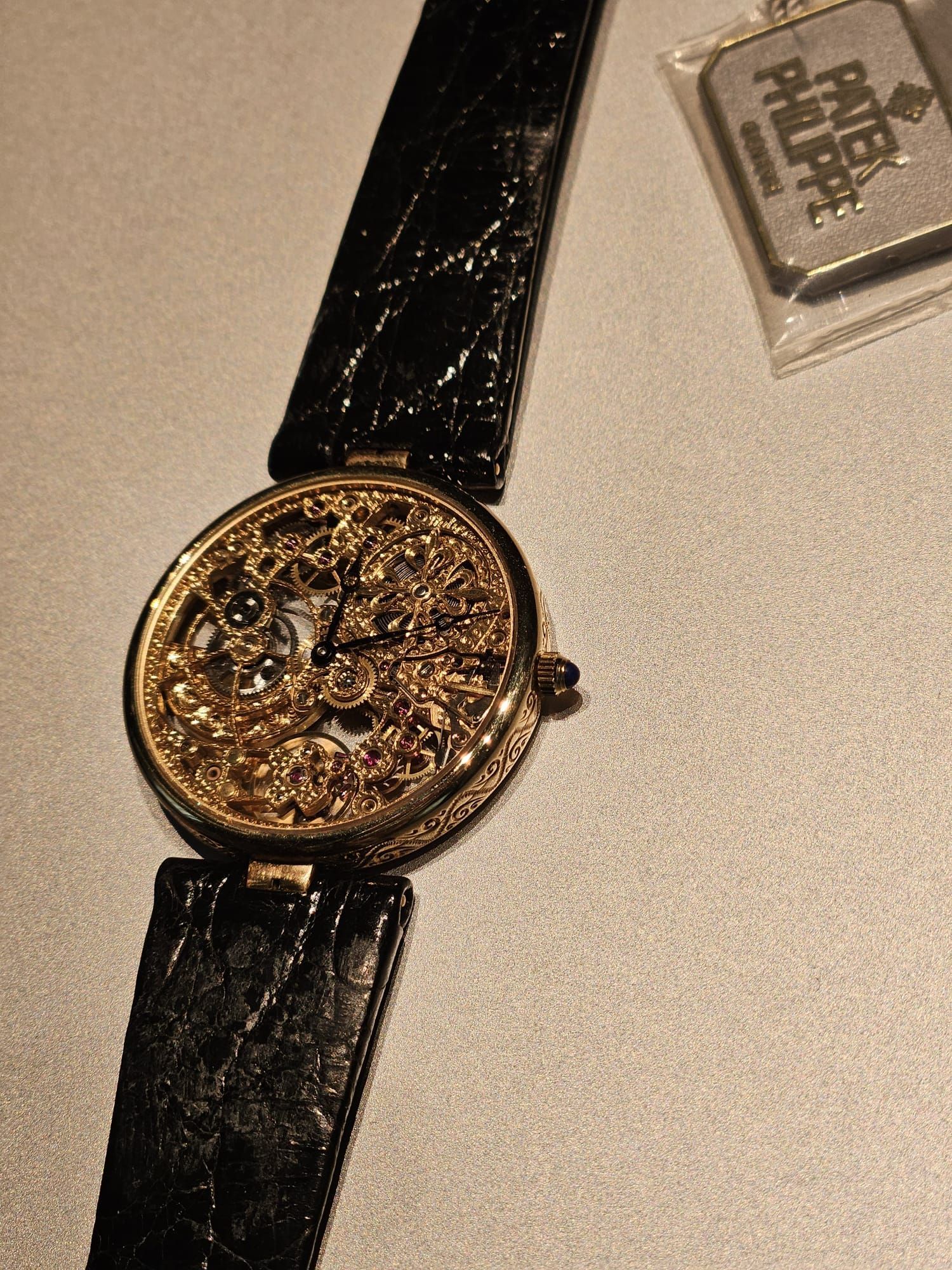 Un uomo in giacca e cravatta indossa un orologio al polso.