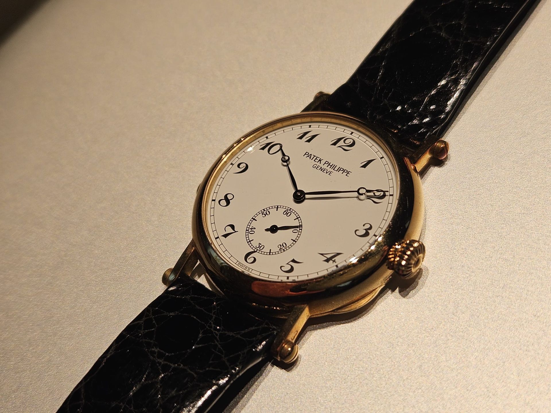 Un orologio Rolex nero e argento è appoggiato su una superficie nera.