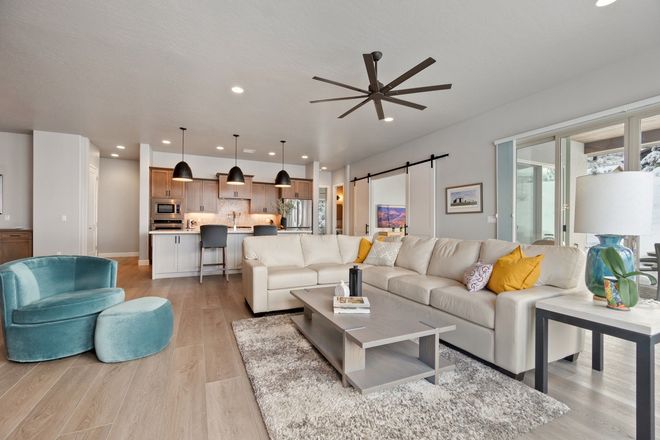 A living room filled with furniture and a ceiling fan.