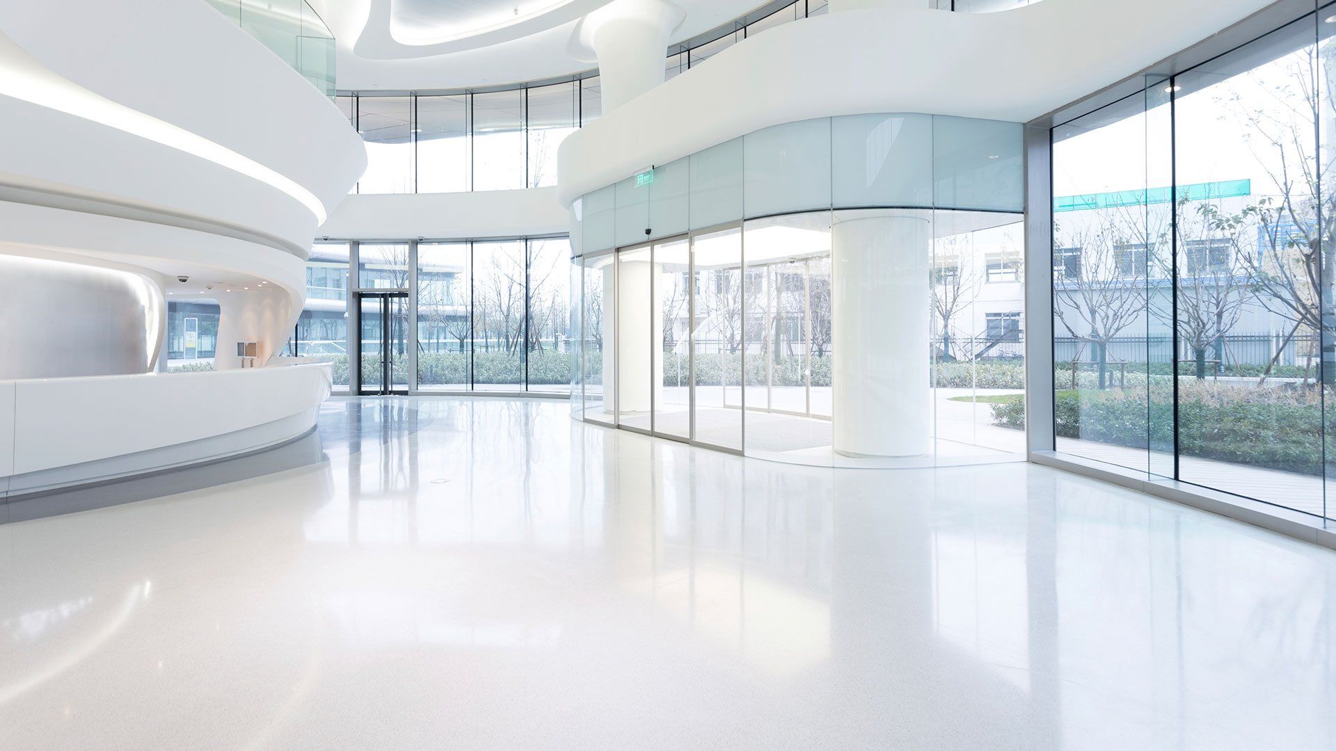 A large empty lobby in a modern building with lots of windows.