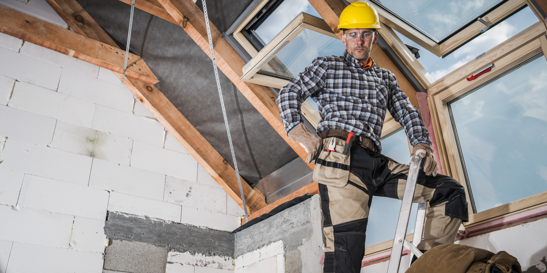 Two men are working on the roof of a house