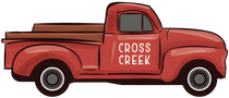 A red truck with the word cross creek on the side.