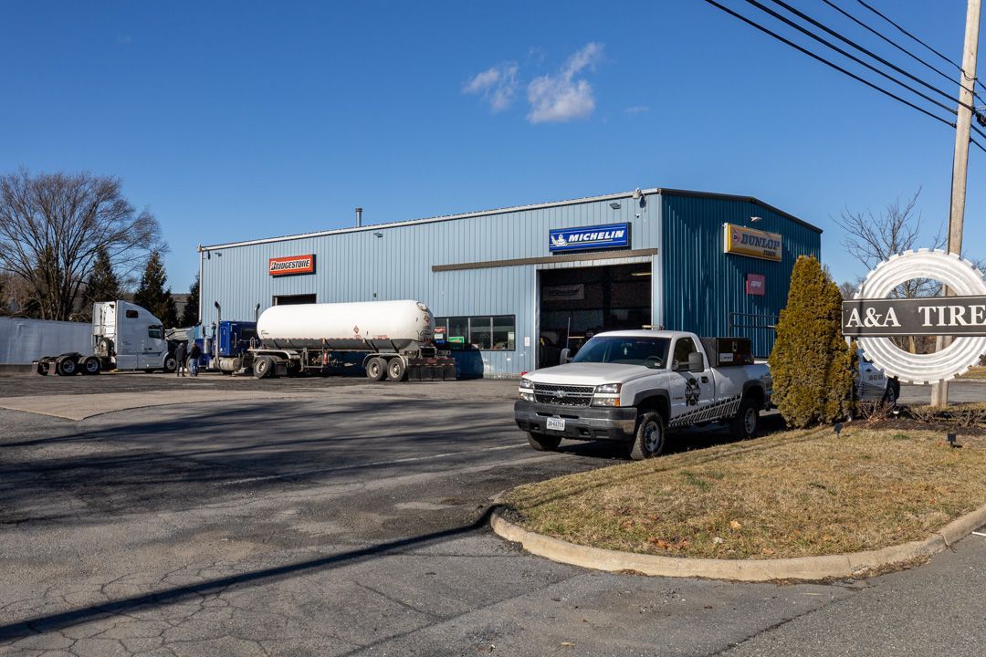 ARA Tires building with truck, gas tank, and sign on a sunny day.