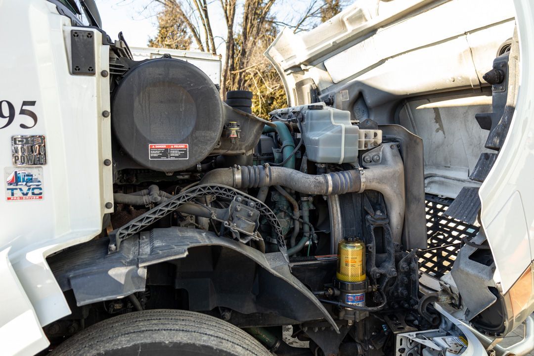 Open hood of a white semi-truck, engine and components visible.