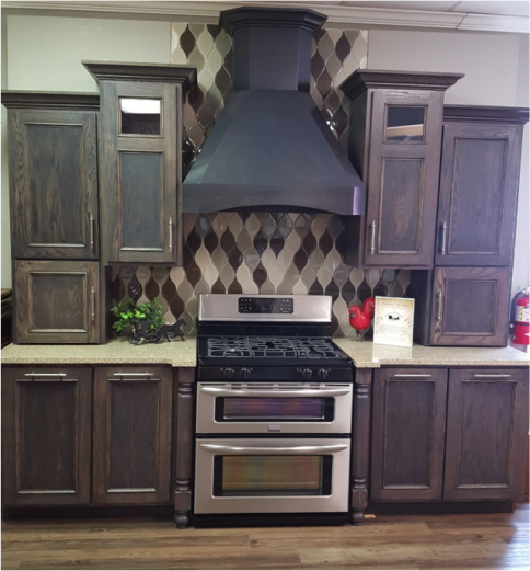 Kitchen with dark wood cabinets, stainless steel stove, and large black range hood.