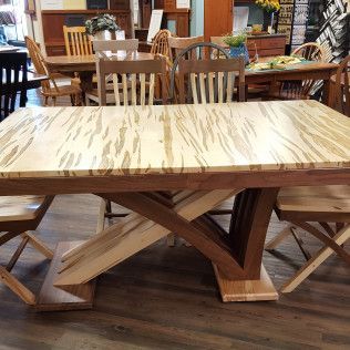 Marble-topped wooden dining table with matching chairs in a furniture showroom