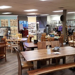 Furniture showroom with wooden tables and chairs under bright ceiling lights