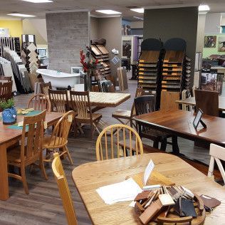 Furniture store showroom with wooden tables, chairs, and stacked shelves in a spacious interior