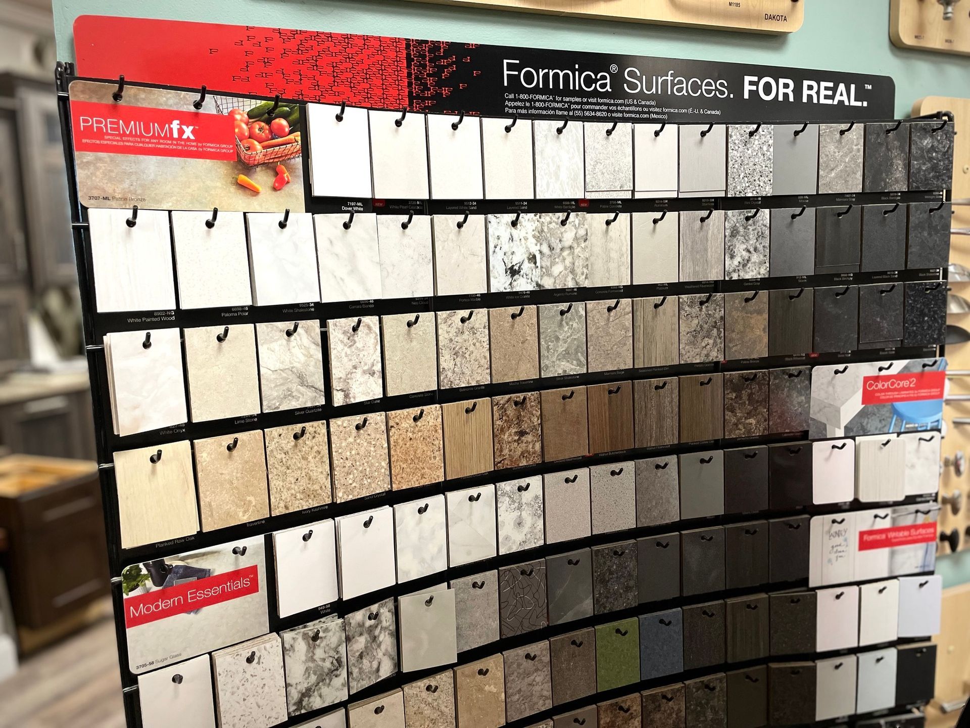 Paint sample display board with rows of white, beige, gray, and dark tiles under showroom lighting