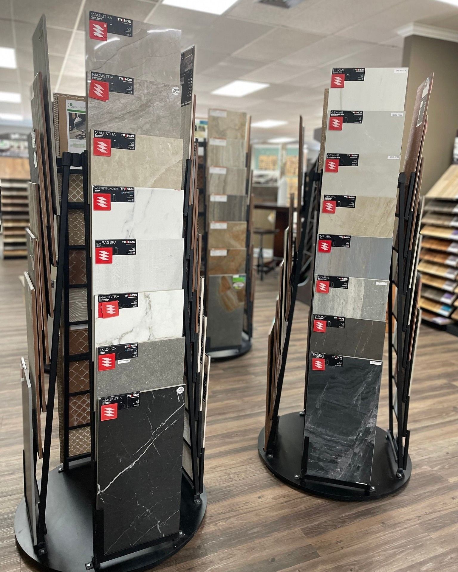 Rotating display racks holding black-and-white acrylic shelves in a store aisle