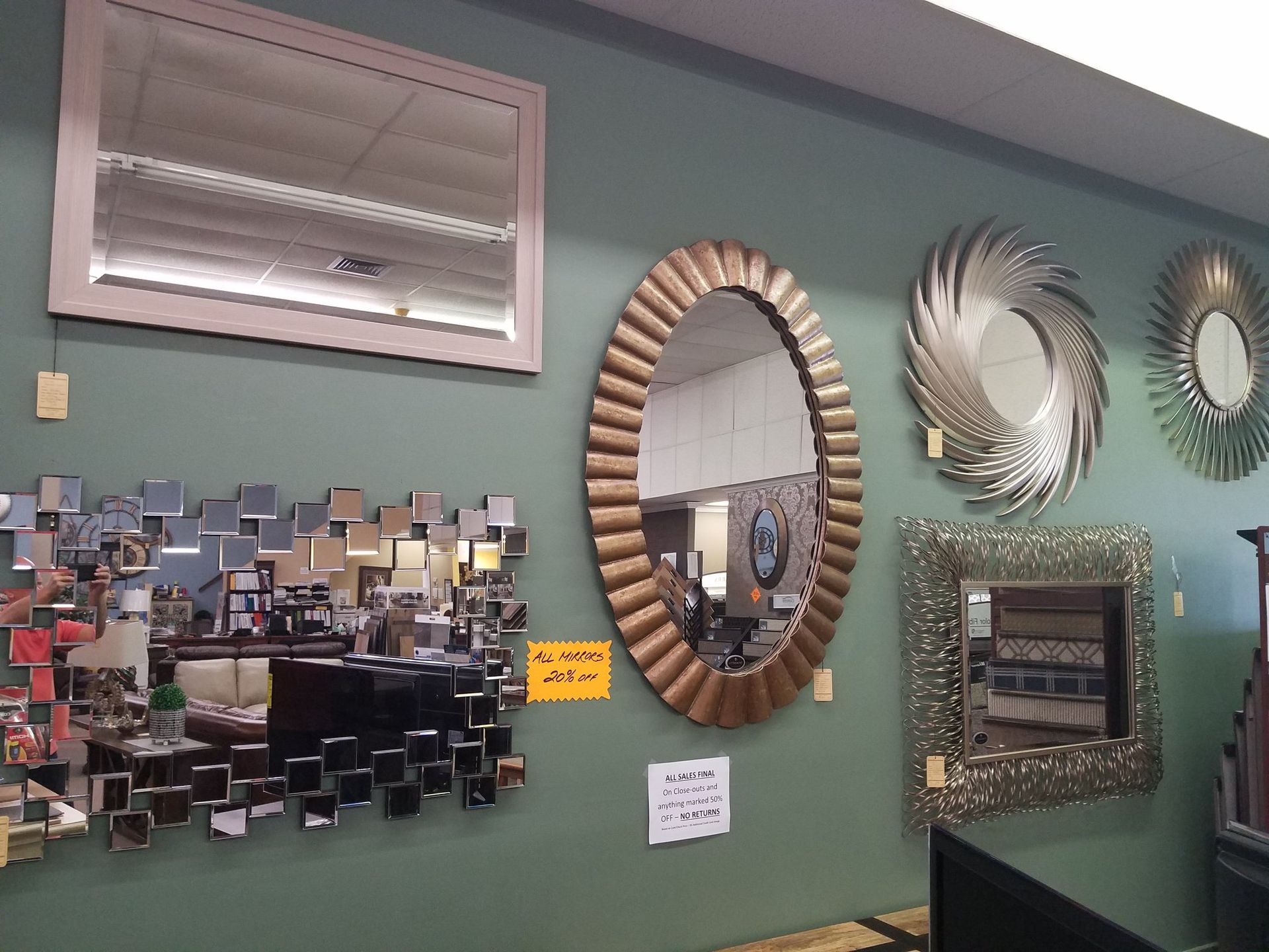Wall with decorative mirrors and a mosaic-style collage in a green room