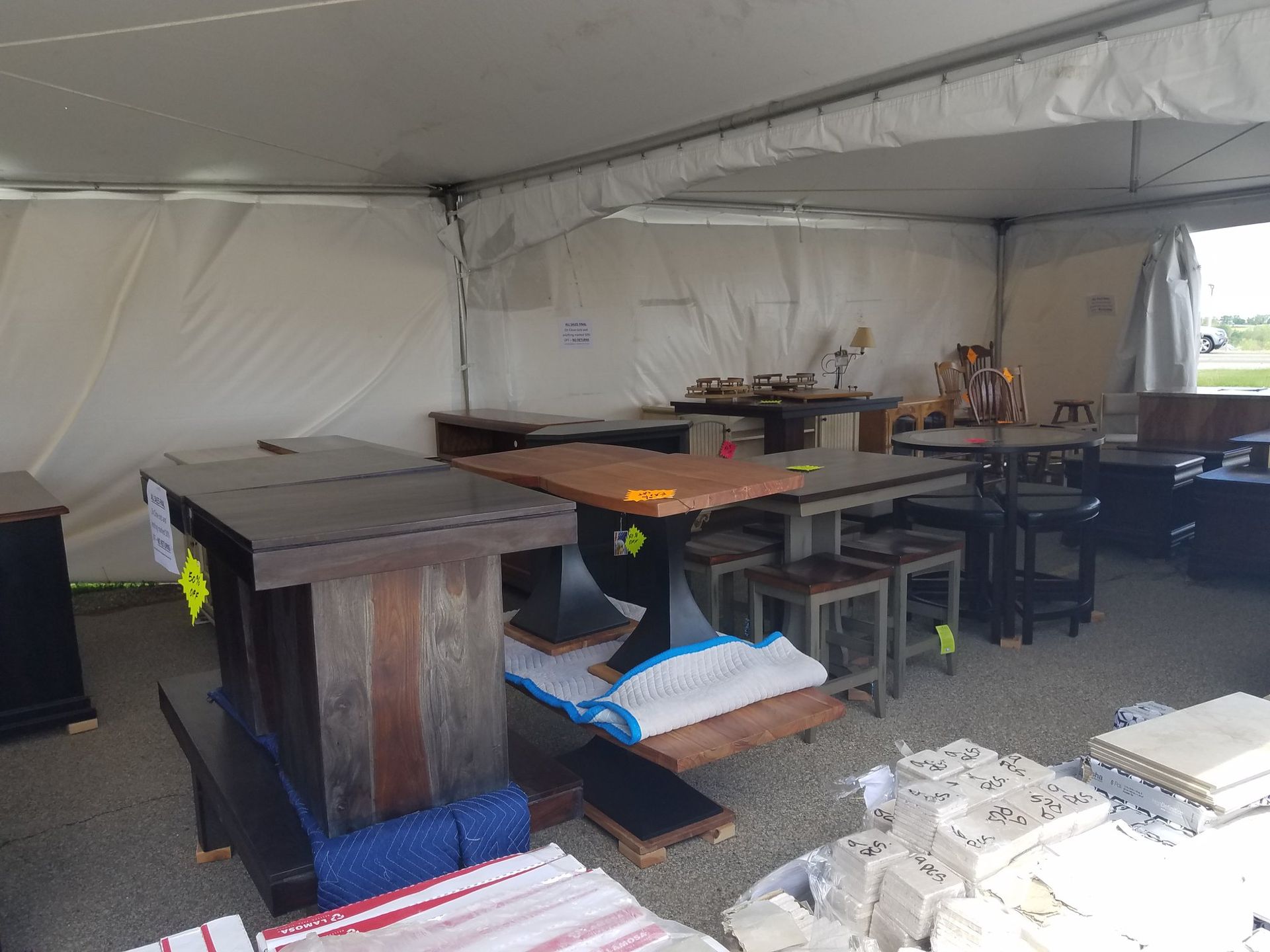 Tents with tables and equipment set up inside a large white event canopy.