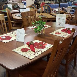 Dining tables set with white placemats, red napkins, and flowers in a restaurant display area
