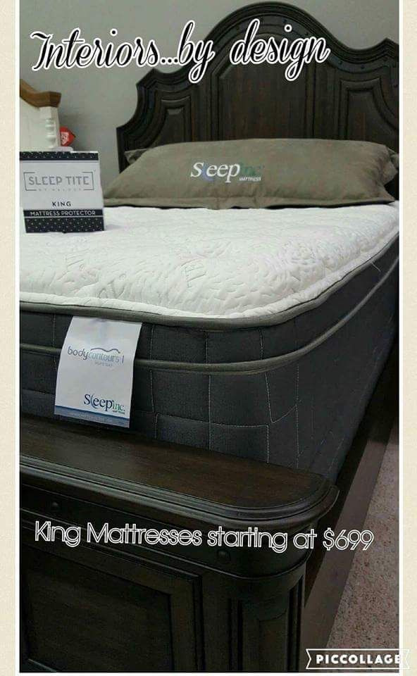 King mattress in a furniture showroom with white bedding and a dark upholstered headboard, labeled $599.