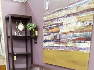 Purple room corner with dark shelf, clock, plant, and large abstract wall art.