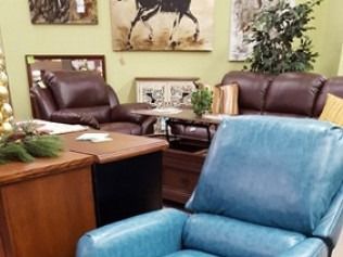 Office waiting area with leather chairs, wooden desk, and blue armchair against green walls
