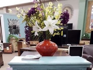 Office lobby with a red vase of white and purple flowers on a counter