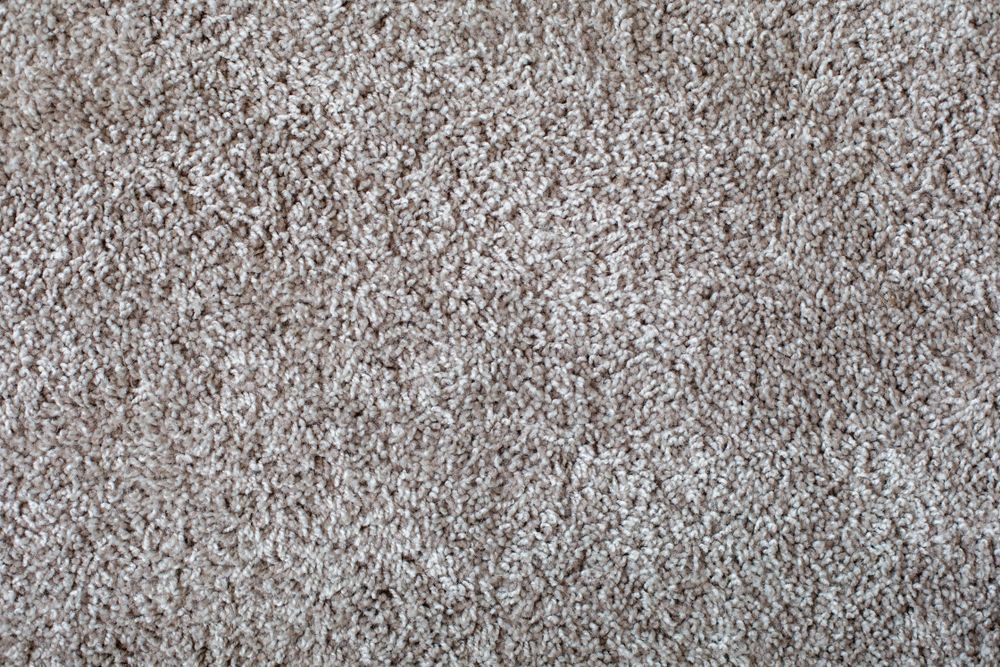 Close-up of beige and gray carpet texture with a speckled pattern