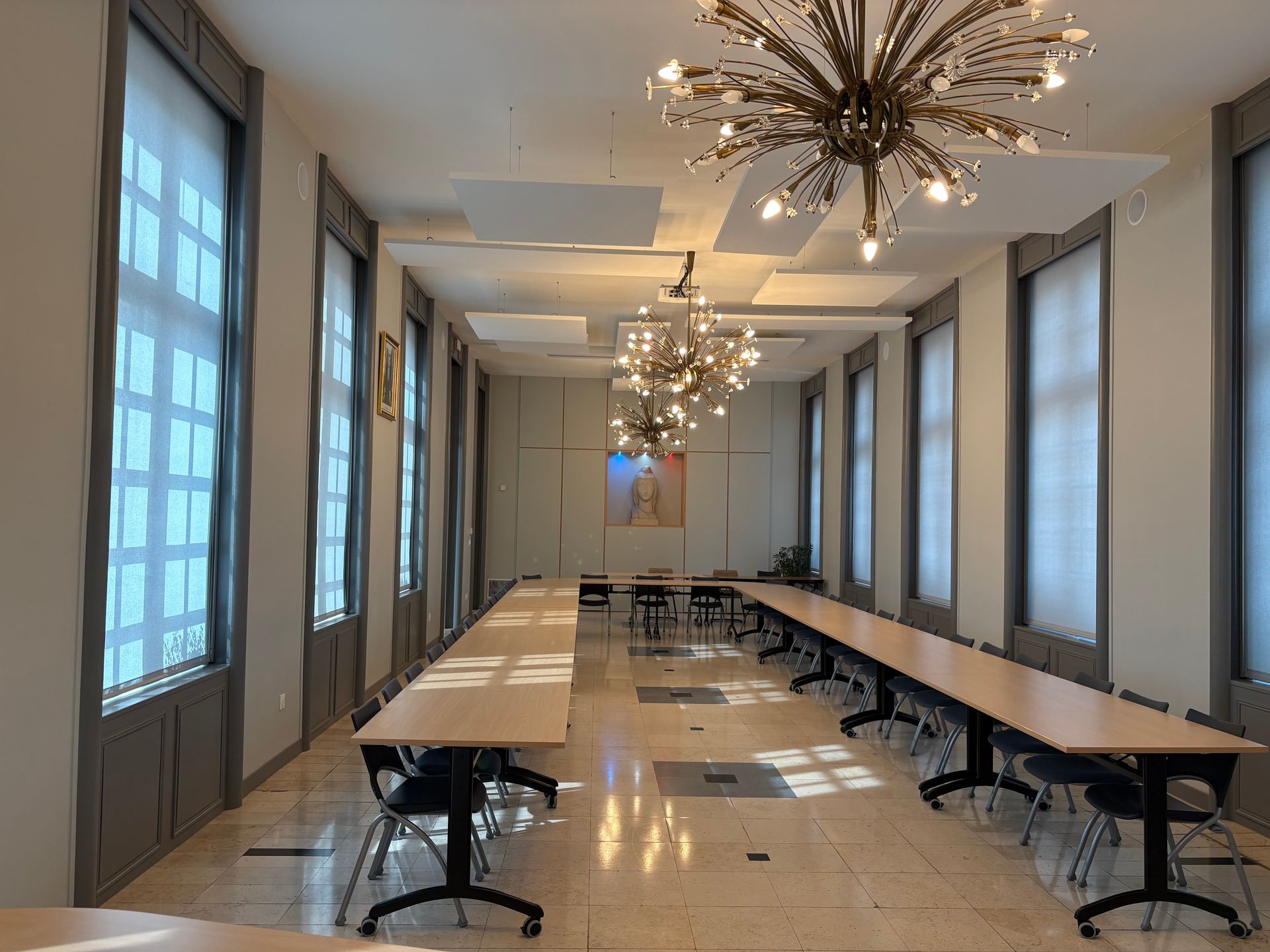 Une salle de formation professionnelle avec des planches à repasser bleues et des tables en bois, aménagée pour la formation pratique ou les cours de couture.