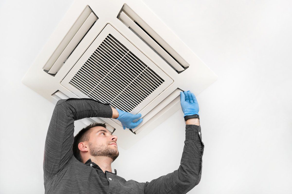 Young Technician Installing Air Conditioner — Nicholasville, KY — Stewart Air Conditioning & Heating