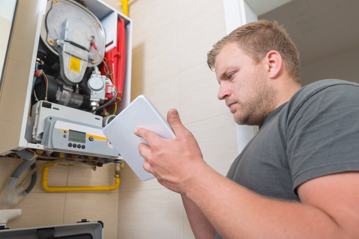 Technician Repairing Gas Furnace — Nicholasville, KY — Stewart Air Conditioning & Heating